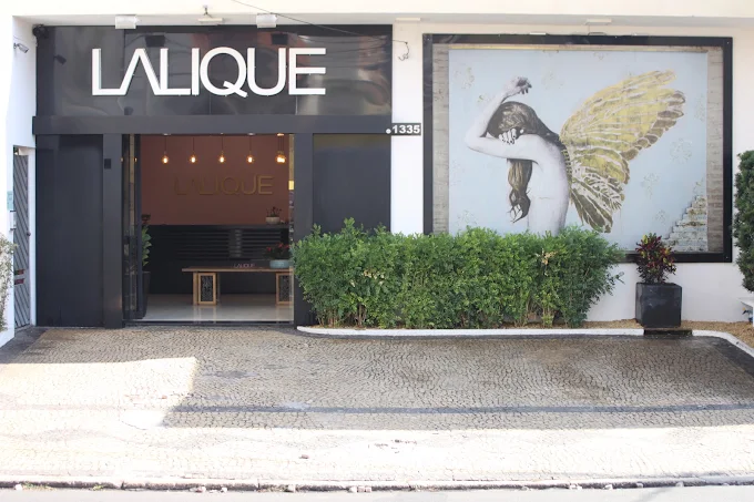 Fachada iluminada da boutique LLQ Lalique ao anoitecer